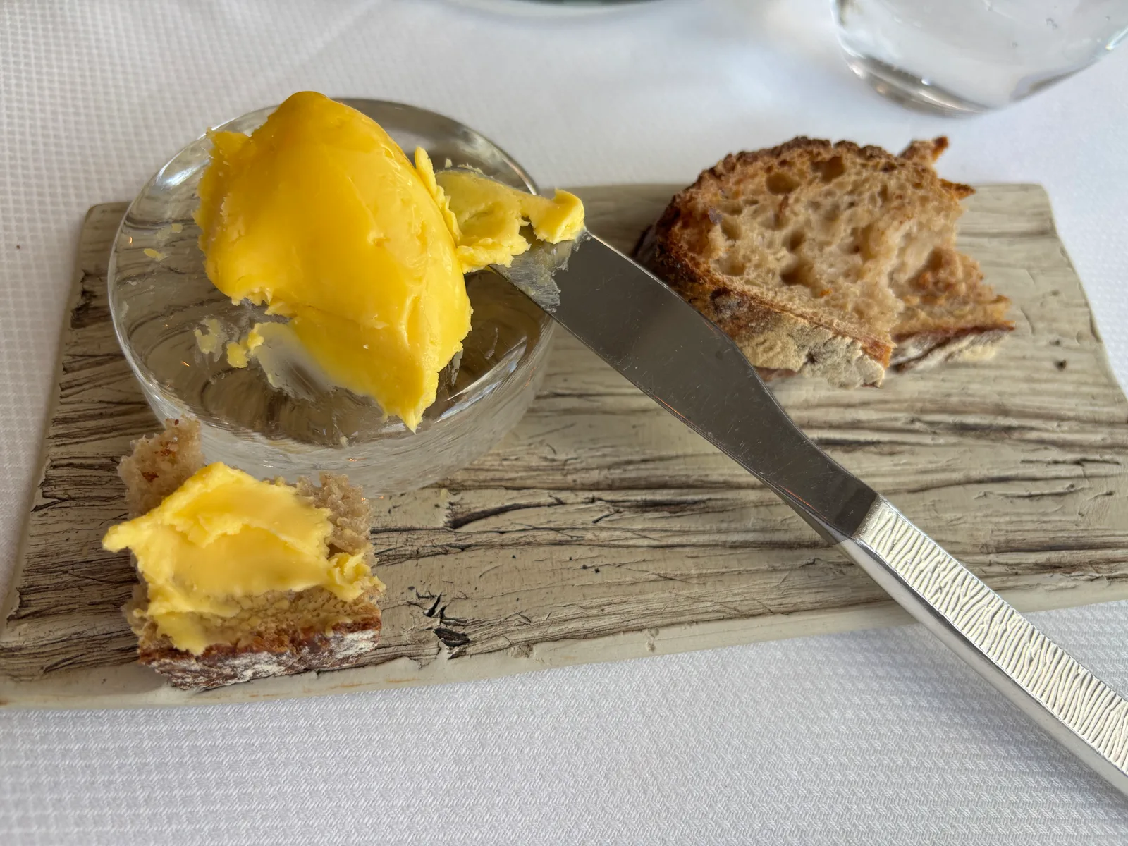 Breton baratte butter served in a glass dish with fresh bread and a spreading knife