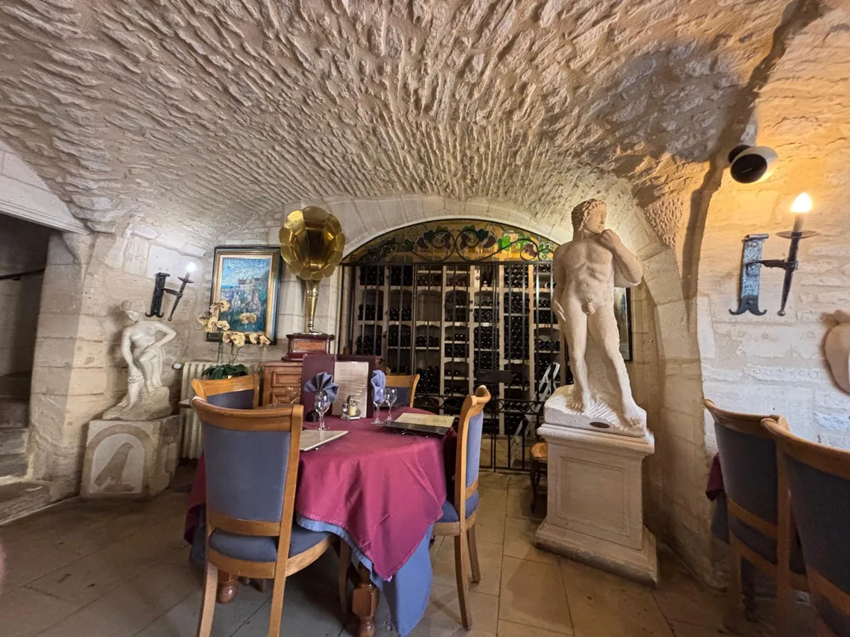 The vaulted cellar room with classical statues and wine racks