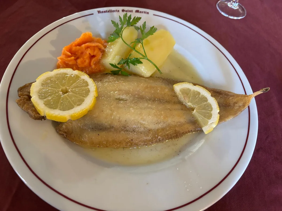 Sole meuniere on a plate marked Hostellerie Saint Martin, with lemon and potato
