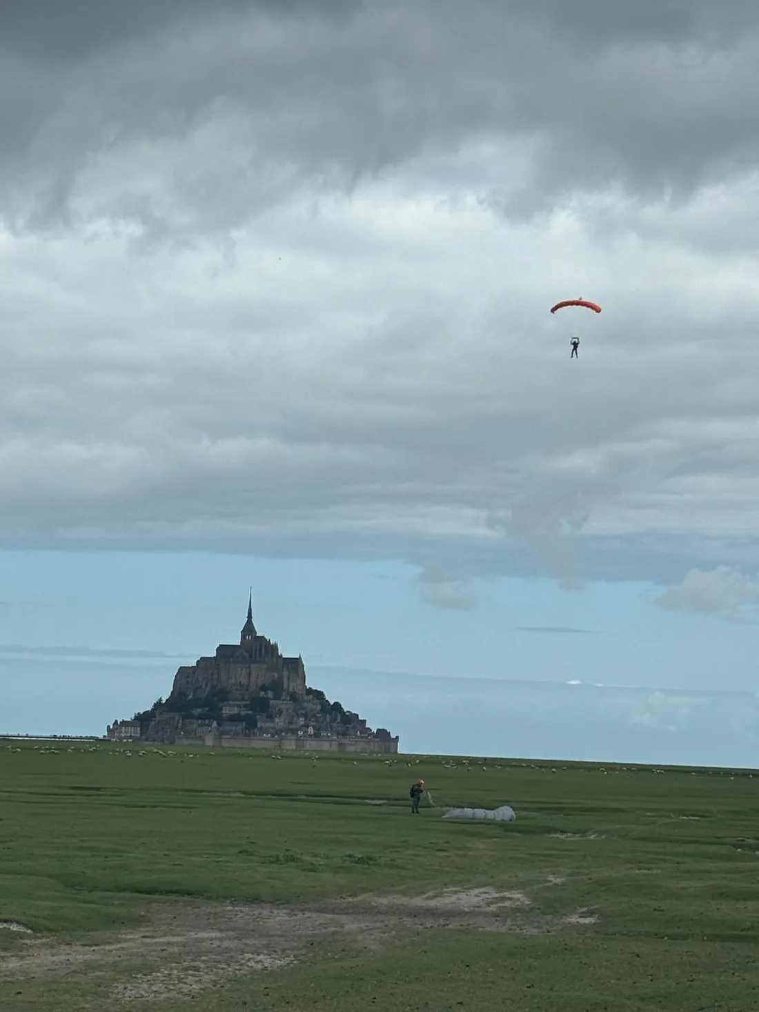 A paratrooper landing on the salt marsh beside Mont-Saint-Michel